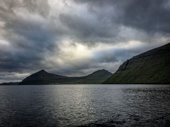 Scenic view of lake by mountain against sky