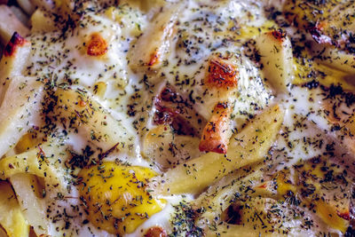 Potato dish with egg and thyme top view, baked in the oven