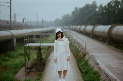 Young woman with eyes closed standing on pipeline