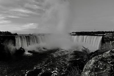 Scenic view of waterfall against sky