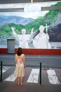 Rear view of woman standing with arms raised