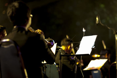 Man playing trumpet in music concert at night