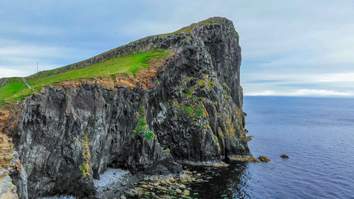 Rock formations by sea against sky