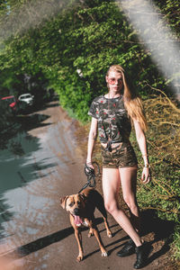 Portrait of young woman with dog on plant