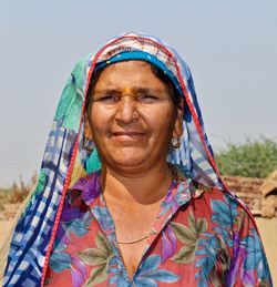 Portrait of smiling woman against sky