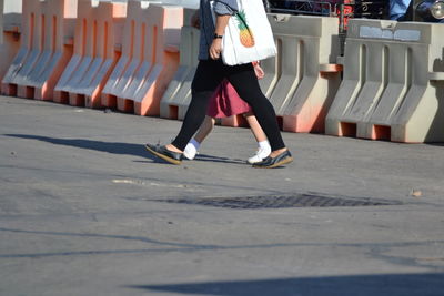 Low section of woman running on street