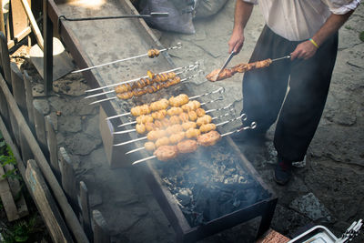 High angle view of man roasting meat on barbeque