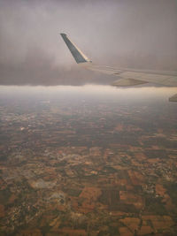 Airplane flying over landscape against sky
