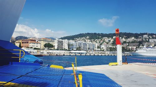 Scenic view of sea by buildings against blue sky