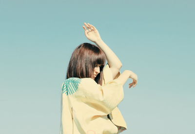 Woman dancing standing against clear sky