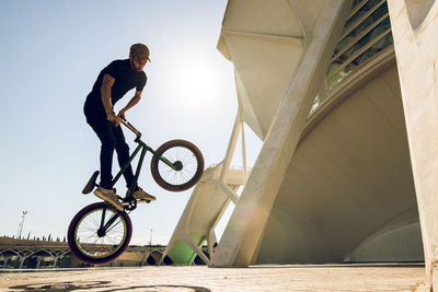 Man performing stunt on bicycle in city 