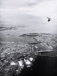 Aerial view of sea and cityscape against sky