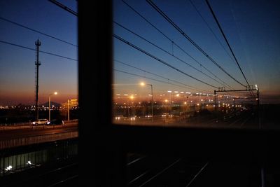 Illuminated railroad tracks against sky at night
