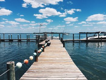 Wooden pier over sea against sky