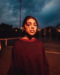 Portrait of beautiful young woman standing against sky