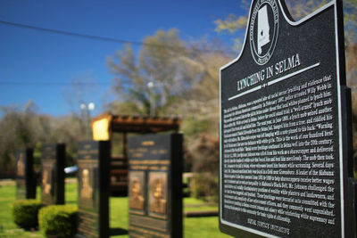 Close-up of information sign against trees