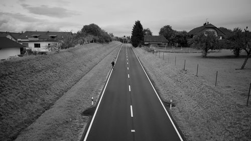 Empty road amidst buildings against sky