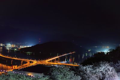 Illuminated light trails on road against sky at night