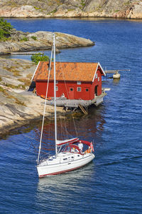 Sailing boat at an idyllic red cottage on the coast