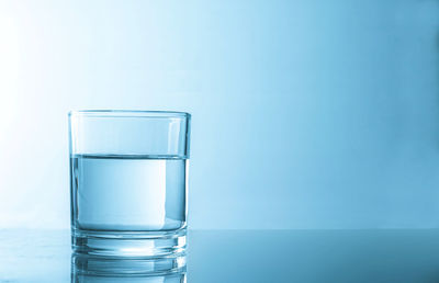 Glass of water against blue background