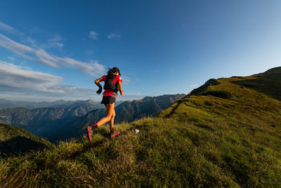 Full length of woman standing on mountain against sky