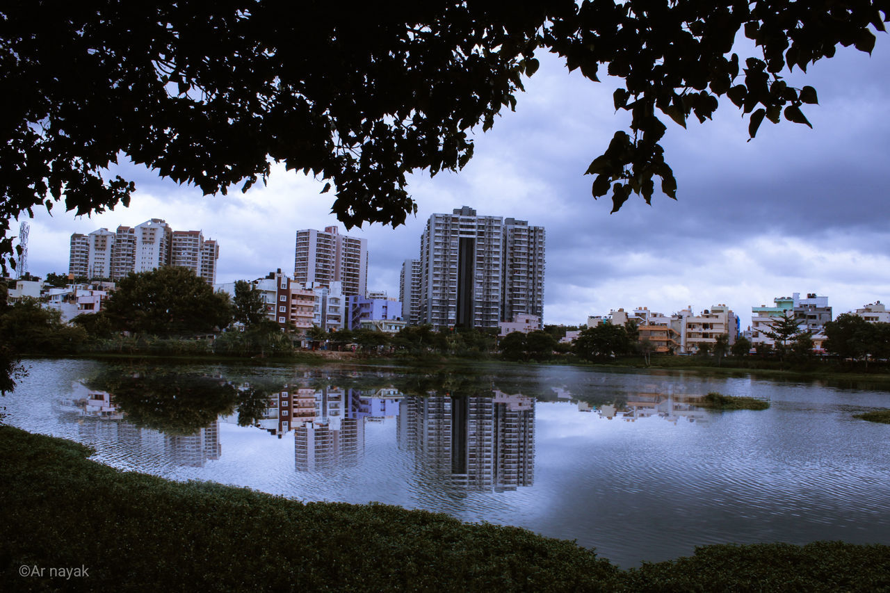 REFLECTION OF BUILDINGS AND TREES IN LAKE