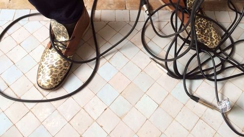 Low section of people standing on tiled floor