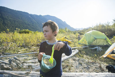 Full length of boy holding food on mountain