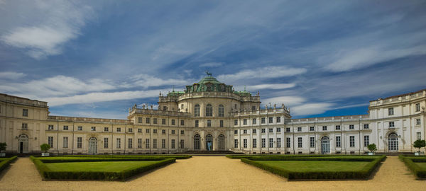 Facade of historical building against cloudy sky