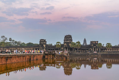 Reflection of temple in water against sky