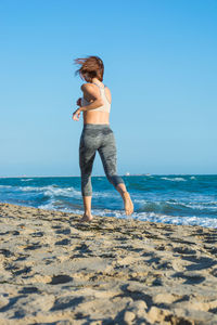 Full length of man on beach against clear sky