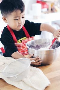 High angle view of boy eating food in kitchen