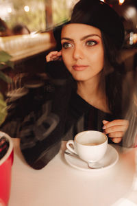 Portrait of young woman sitting on table