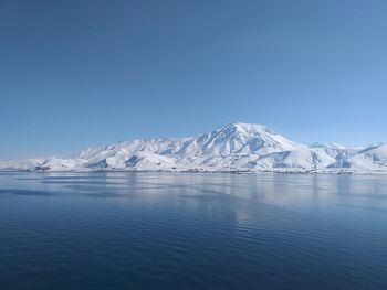 Scenic view of snowcapped mountains against clear blue sky