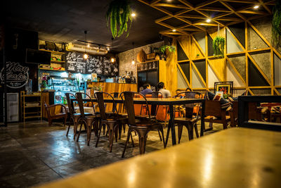 Empty chairs and tables in restaurant at night