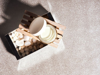 Set of cosmetics, oils, creams on a wooden stand on a silver background.