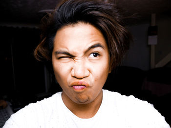 Close-up of young man making face at home