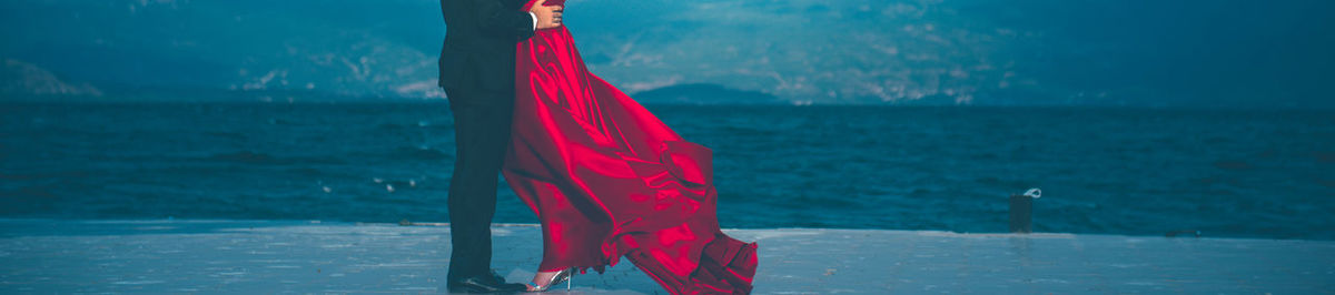 Low section of woman standing by sea