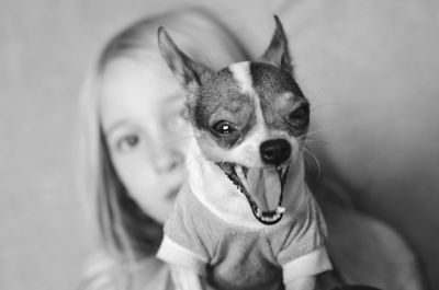 Portrait of girl with chihuahua dog yawing at home