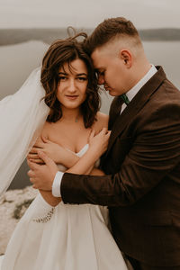 Portrait of bride and bridegroom standing at home