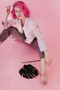 Portrait of woman with pink hair against gray background