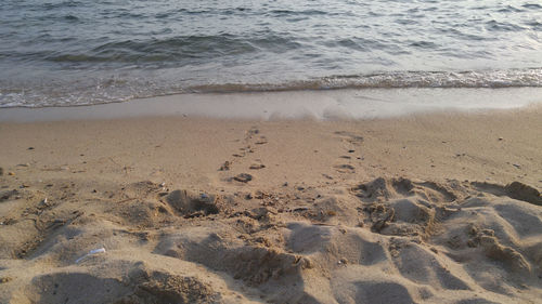 High angle view of footprints on sand at beach