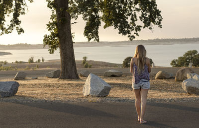 Full length of young woman standing on landscape