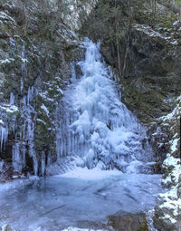 Scenic view of waterfall in forest during winter