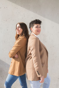 Portrait of woman standing against wall