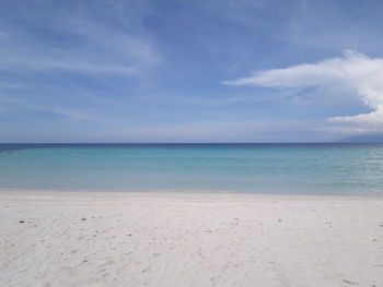 Scenic view of beach against blue sky