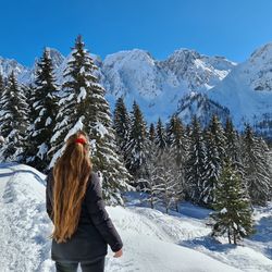 Rear view of woman on snowcapped mountain against sky