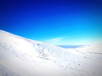 Scenic view of snowcapped mountain against blue sky