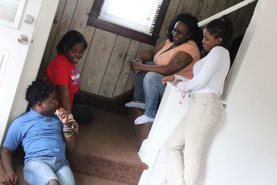 Tilt shot of happy family on staircase at home