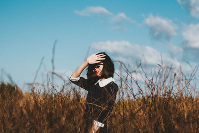 Woman holding camera on field